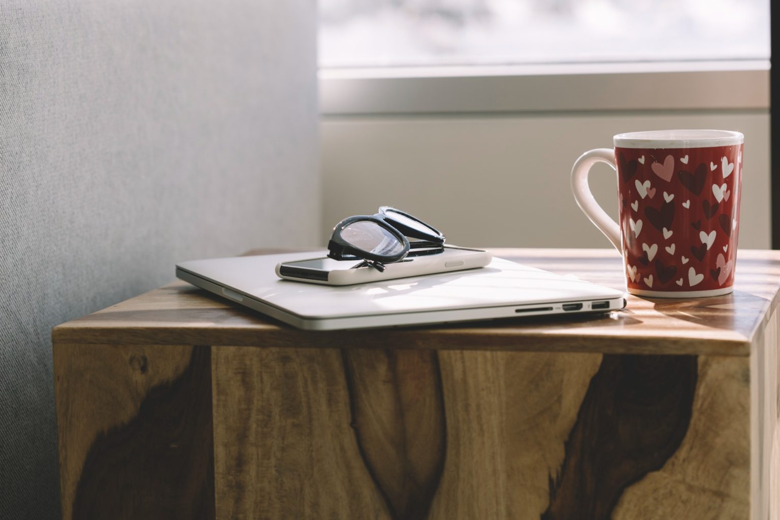 Cuaderno de hábitos y taza de café en un escritorio ordenado con luz natural.